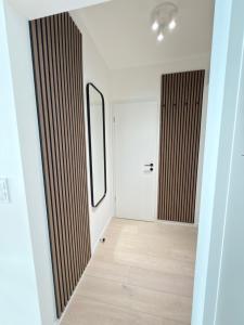 a hallway with a white door and a mirror at Anna Lakeside Apartman in Gárdony +13 photos