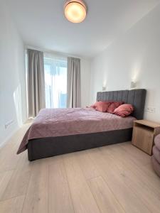 a bedroom with a large bed with pink pillows at Anna Lakeside Apartman in Gárdony