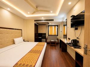 a hotel room with a bed and a television at Hotel A One Luxury - Premium Stay Puri Beach in Puri