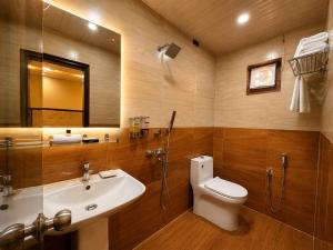 a bathroom with a sink and a toilet and a mirror at Hotel A One Luxury - Premium Stay Puri Beach in Puri