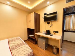 a room with a bed and a desk with a television at Hotel A One Luxury - Premium Stay Puri Beach in Puri