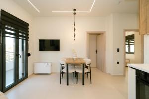 a kitchen and dining room with a table and chairs at Aether Home in Ammoudia +22 photos