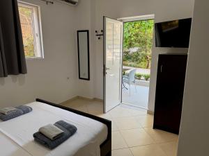 a bedroom with a bed and a sliding glass door at Tomi garden apartment in Sarandë