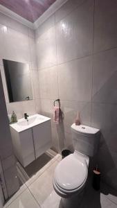 a bathroom with a white toilet and a sink at The Kempton Star in Kempton Park +35 photos