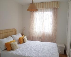 a bedroom with a bed with yellow and white pillows at Casa de Concha in Burela de Cabo