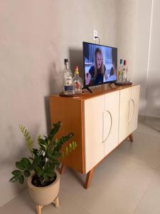 a tv sitting on top of a dresser at Flat Aconchego no Setor Oeste a 50m do Lago das Rosas, apto novo in Goiânia
