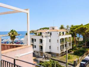 a white building with the ocean in the background at il grippiale in Aci Castello