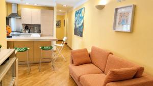 a living room with a couch and a kitchen at il grippiale in Aci Castello