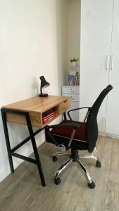 a desk with a chair with a lamp on it at Nuvali Studio Retreat Free Parking Fast WiFi Pool in Calamba