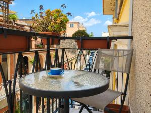 a table and chair on a balcony with a coffee cup at il grippiale in Aci Castello +3 photos