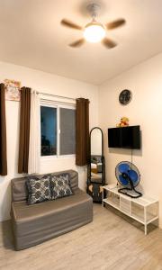 a living room with a couch and a ceiling fan at Nuvali Studio Retreat Free Parking Fast WiFi Pool in Calamba