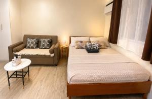 a small room with two beds and a couch at Nuvali Studio Retreat Free Parking Fast WiFi Pool in Calamba