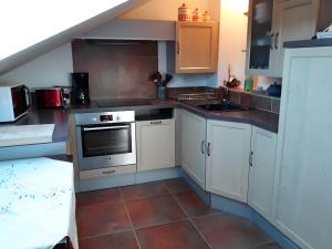 a small kitchen with white cabinets and a sink at Domaine De Jassenove in Millau +9 photos
