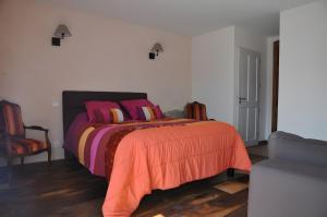 a bedroom with a bed with colorful blankets and pillows at Domaine De Jassenove in Millau