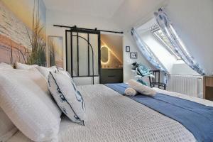 a bedroom with a large white bed with pillows at Les Gîtes Shu-no in Pléhédel