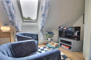 a living room with two chairs and a television at Les Gîtes Shu-no in Pléhédel +61 photos