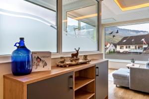 a large blue vase sitting on a table in a room with windows at Azuria Schwarzwald Loft in Kappelrodeck +54 photos