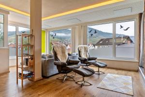 a living room with two chairs and a large window at Azuria Schwarzwald Loft in Kappelrodeck