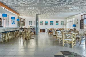 a restaurant with wooden chairs and tables and a bar at Hotel Albatros in Karpathos