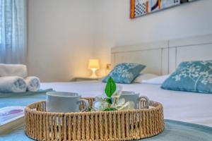 a basket filled with cups and saucers on a bed at Chalet Irene by dracmallorca in Santanyi +39 photos