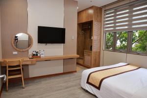 a bedroom with a bed and a desk with a television at Viễn Dung Hotel in Buon Ma Thuot