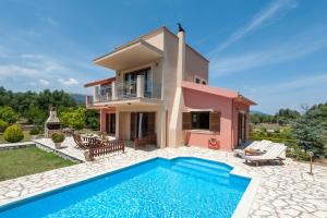 a villa with a swimming pool in front of a house at Penelope Villas in Sami