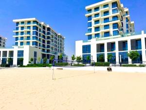 a volleyball court on the beach in front of buildings at Luxury Sea Living in Sharjah