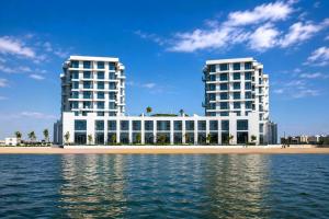 two tall buildings next to a beach and the water at Luxury Sea Living in Sharjah