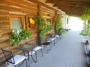 a row of tables and chairs on a patio at Viesu māja Forrest in Dzimtmisa