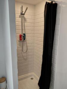 a shower with a black shower curtain in a bathroom at Studio le 174 in Mazan