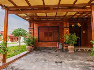 an outdoor patio with a wooden pergola at Griya Mandara Homestay Prambanan in Bugisan