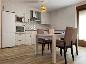 a kitchen with a table and chairs in a room at R2R - Apartamentos Prellezo - C20C03 in Prellezo