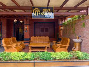a group of chairs and a wooden table on a patio at Griya Mandara Homestay Prambanan in Bugisan