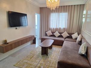 a living room with a couch and a flat screen tv at Super Appartement Sidi Rhal in Dar Hamida +1 photo