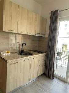 a kitchen with a sink and a window with a patio at Vila Manuel in Shëngjin