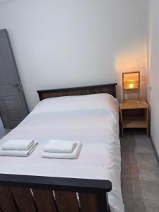 a white bed with two folded towels on it at Arami Guest House in Dilijan