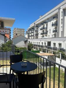 a balcony with a table and chairs and a building at Vila Manuel in Shëngjin
