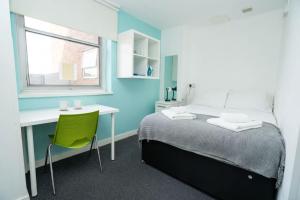 a bedroom with a bed and a desk and a window at Budget En-suite Room in Coventry City Centre in Coventry