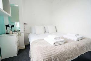 a bedroom with a white bed with towels on it at Budget En-suite Room in Coventry City Centre in Coventry
