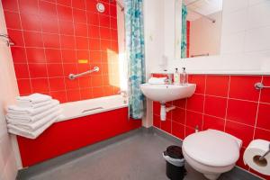a red bathroom with a toilet and a sink at Budget En-suite Room in Coventry City Centre in Coventry