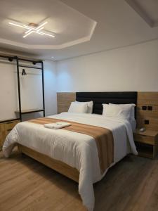 ein Schlafzimmer mit einem großen Bett und einem Deckenventilator in der Unterkunft Haus in Enugu