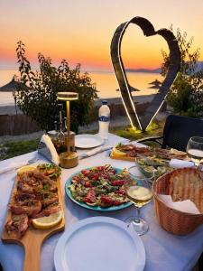 a table topped with plates of food and a heart at Blue Camping in Borsh, Vlorë in Borsh