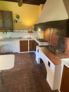 a kitchen with a stove and a brick floor at il MOLENDINO in Calci +11 photos