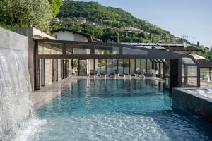 a swimming pool with a waterfall in a house at Village Hotel Lucia in Tremosine Sul Garda