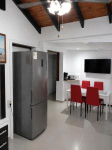 a kitchen with a stainless steel refrigerator and red chairs at Casa Solymar completa 3 dormitorios 5 camas Hasta 6 personas RESERVAS SOLO CON SEÑA in Ciudad de la Costa