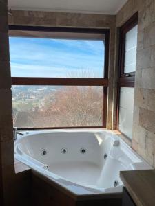 a bath tub in a bathroom with a large window at Hotel Peregrino Suites in Concepción +18 photos