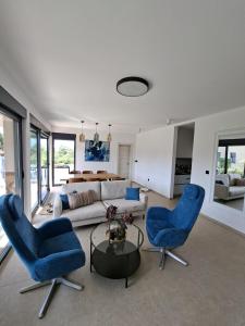 a living room with two blue chairs and a couch at Vila Mila Private Pool Retreat in Radetići