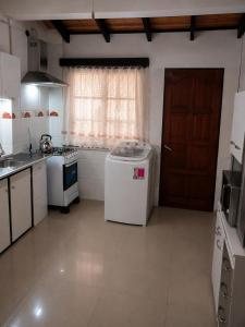 a kitchen with a white refrigerator and a window at Casa Solymar completa 3 dormitorios 5 camas Hasta 6 personas RESERVAS SOLO CON SEÑA in Ciudad de la Costa +12 photos