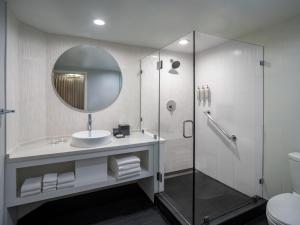a bathroom with a shower and a sink and a mirror at Renaissance Orlando Resort - Disney Springs Area - Free Shuttle & Early Entry to Disney Theme Parks in Orlando