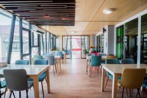 a cafeteria with tables and chairs and windows at Breezehill Khao Kho Hotel in Khao Kho